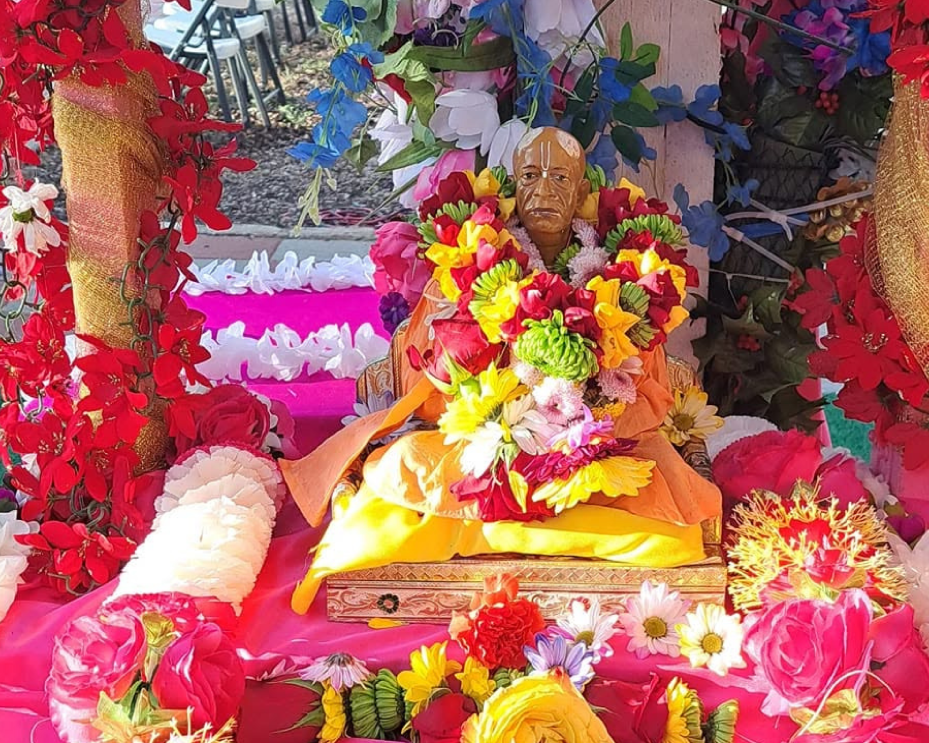 Srila Prabhupada murti beautifully adorned with colorful flowers at ISKCON Cedar Park