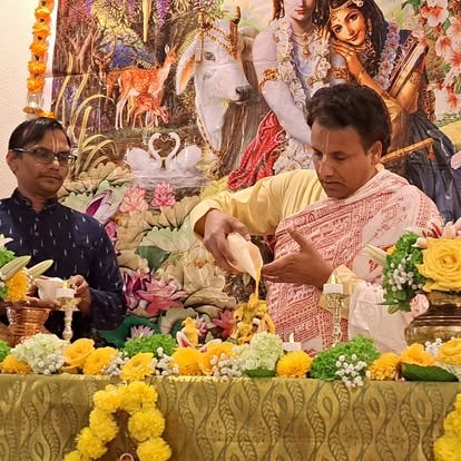 Men arranging flowers at religious ceremony altar at ISKCON Cedar Park