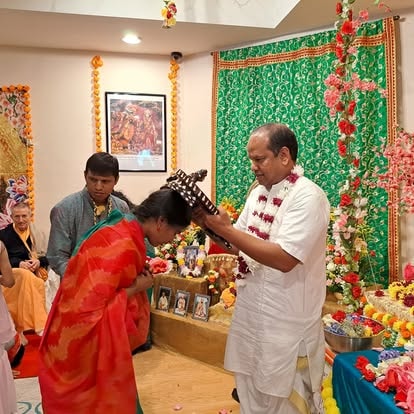 Man placing flower garland on woman at community event